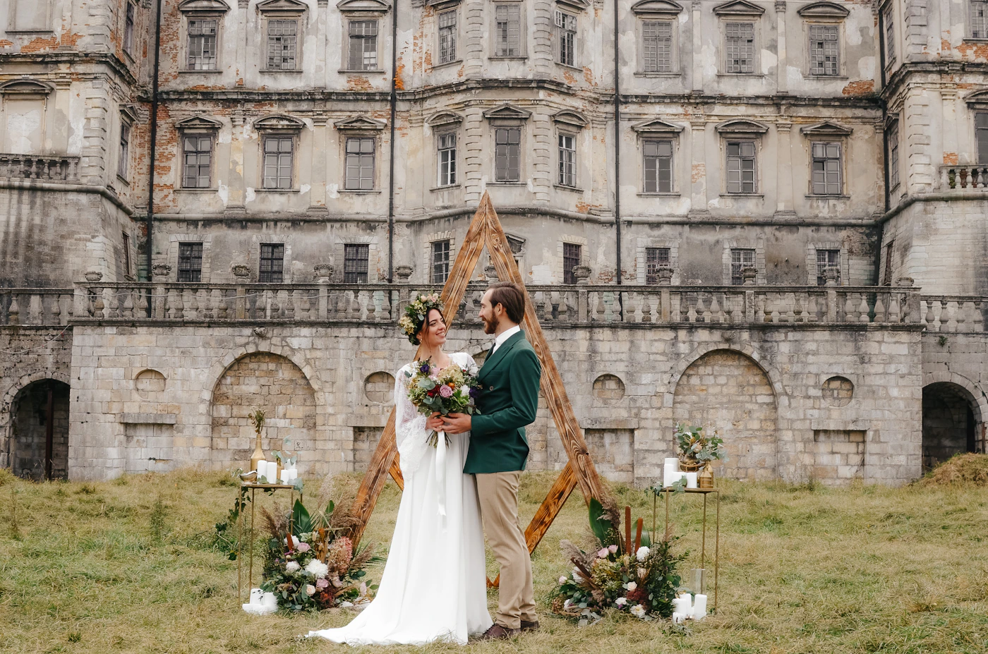 Bride and groom standing in front of a grand historic stone building