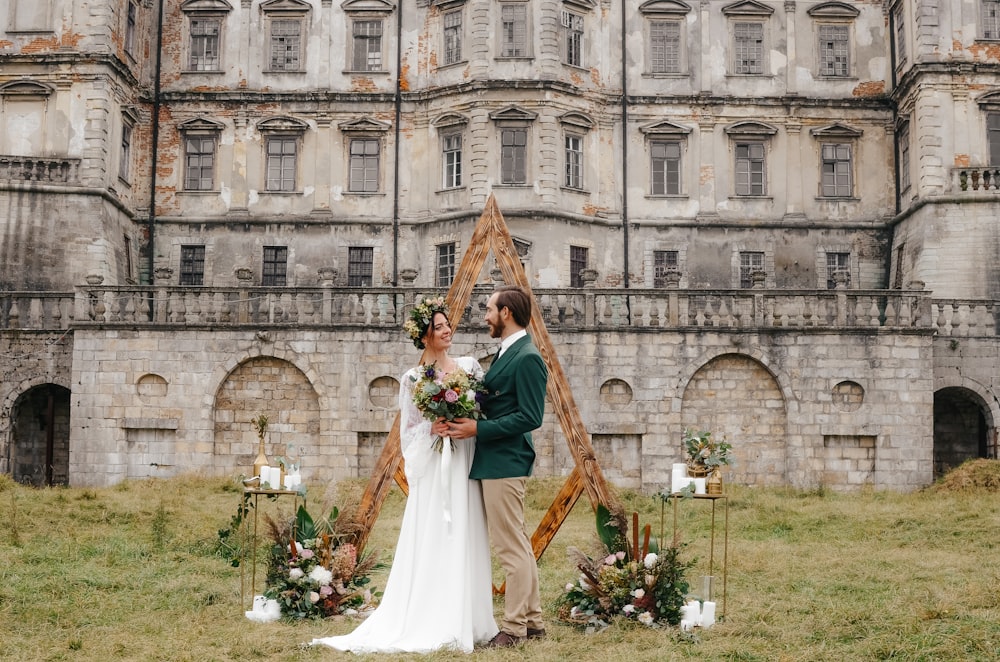 a bride and groom posing in front of a large building