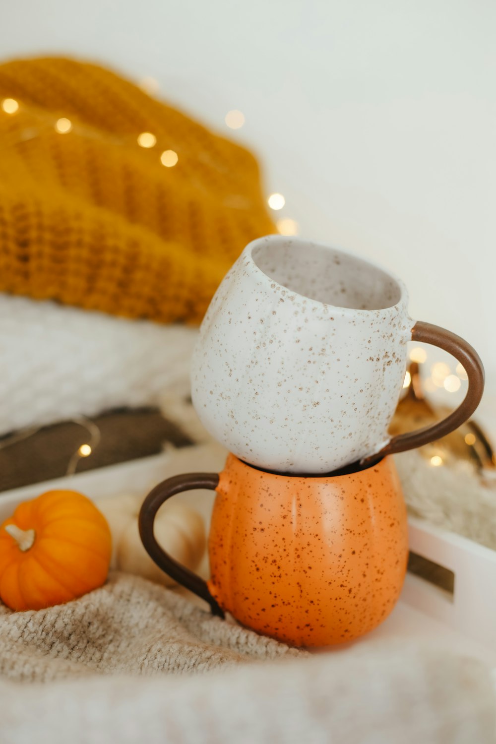 una taza de té junto a una calabaza y una rodaja de naranja