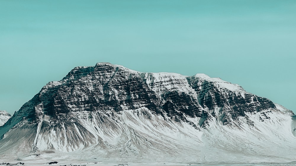 a snowy mountain with a blue sky