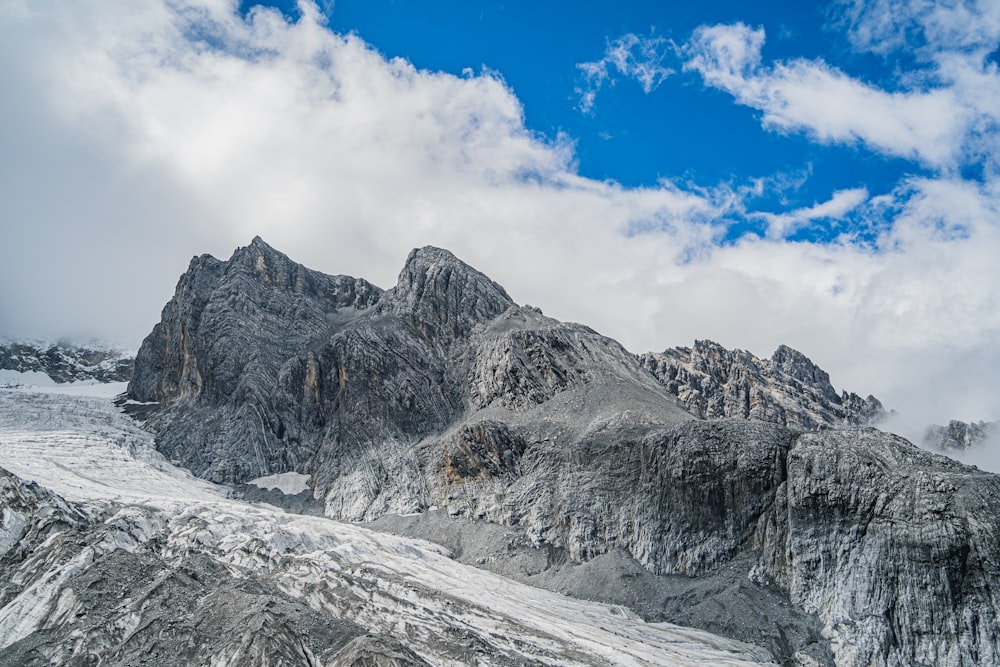 a snowy mountain with clouds