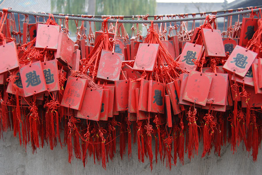 Paper strips with Chinese riddle characters hanging from red lanterns at a traditional Lantern Festival