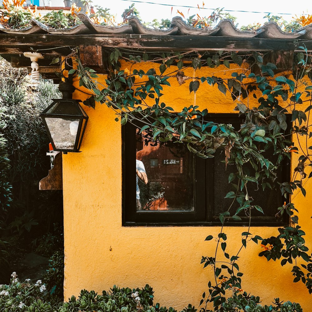 a yellow house with a window and a lamp post