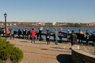 A group photo of diverse community members holding a banner that reads 'Voice of Immigrants & Community Empowerment.'