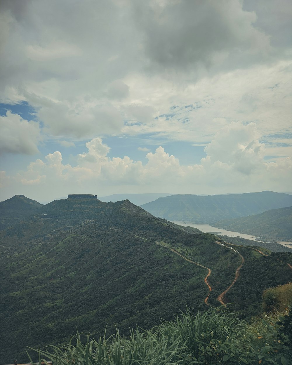 a landscape with hills and a body of water in the distance