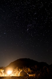 Hikers camping under a starry sky near Mount Rinjani’s crater rim.