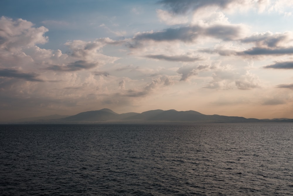 a body of water with mountains in the background