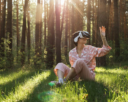 a person sitting in a grassy area with trees in the background