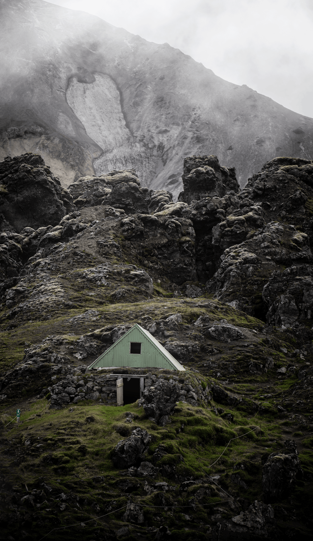 a small building on a rocky mountain