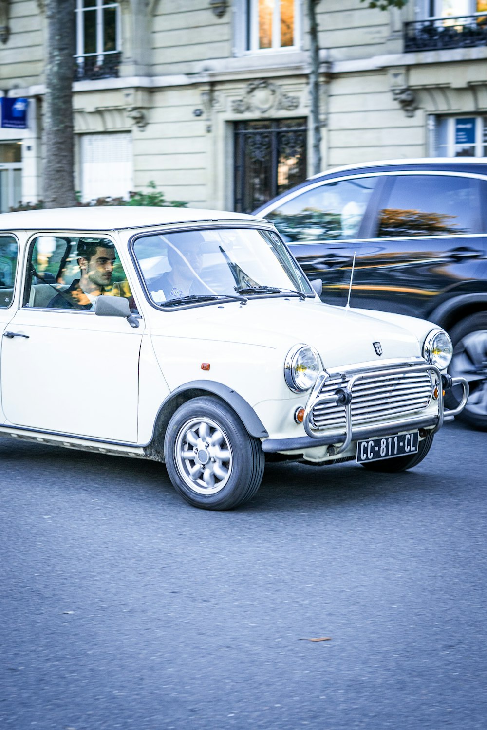 a person driving a small white car