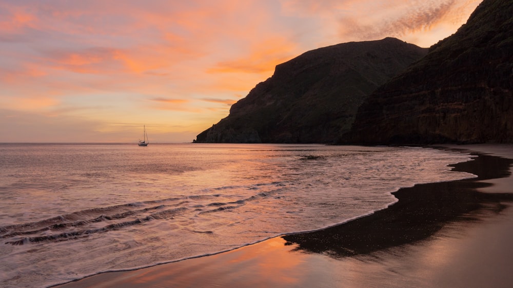 a boat in the water by a rocky cliff