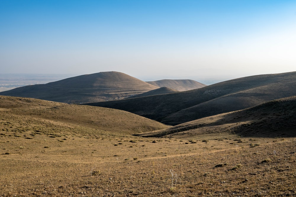 a landscape with hills and a blue sky