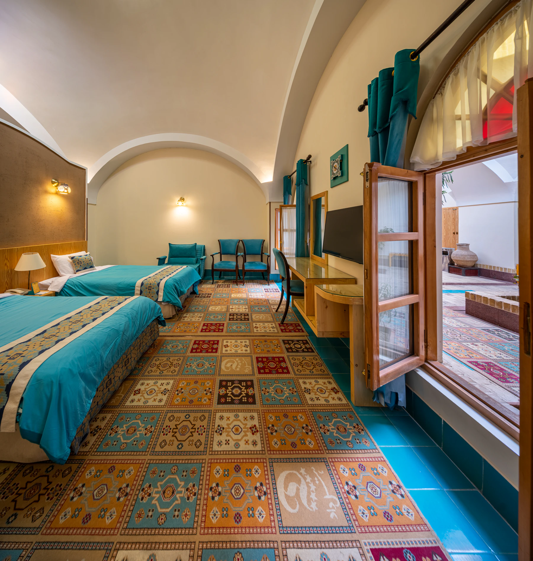 Bedroom with colorful tiled floor and tall windows