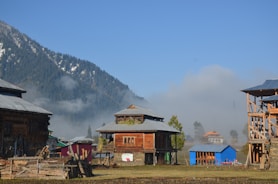 a group of buildings with mountains in the background