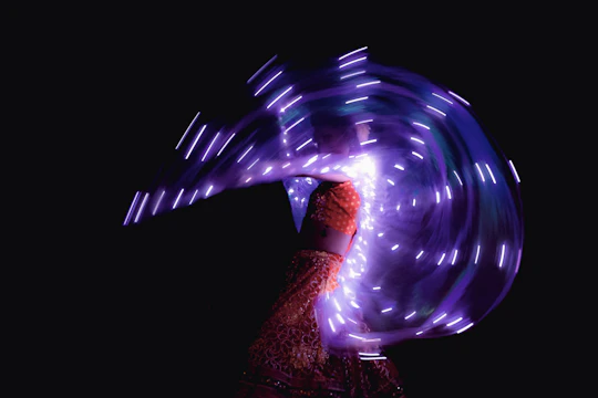 An animated girl wearing a glowing, magical dress surrounded by sparkling lights.