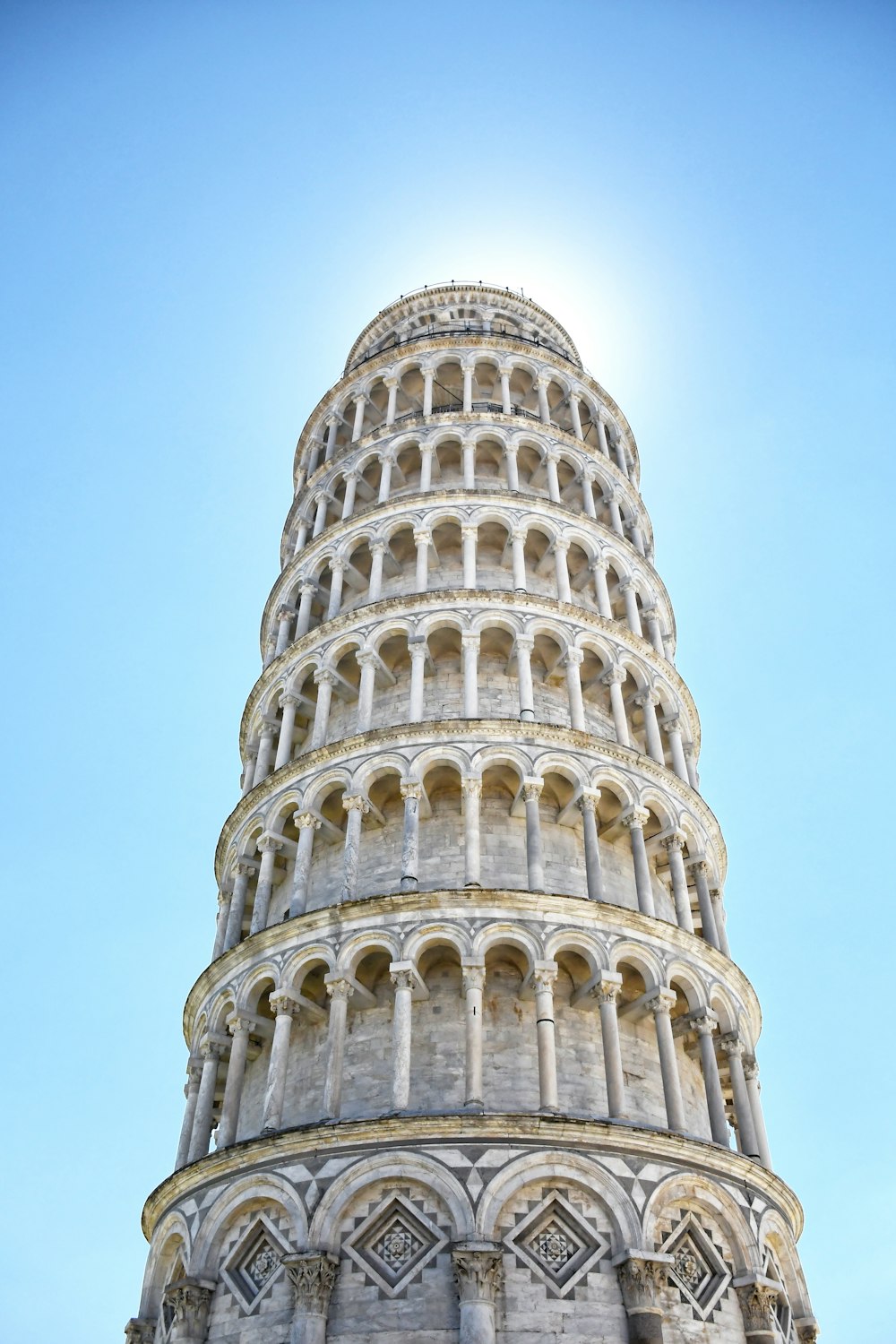 ein großes Kuppelgebäude mit dem Schiefen Turm von Pisa im Hintergrund