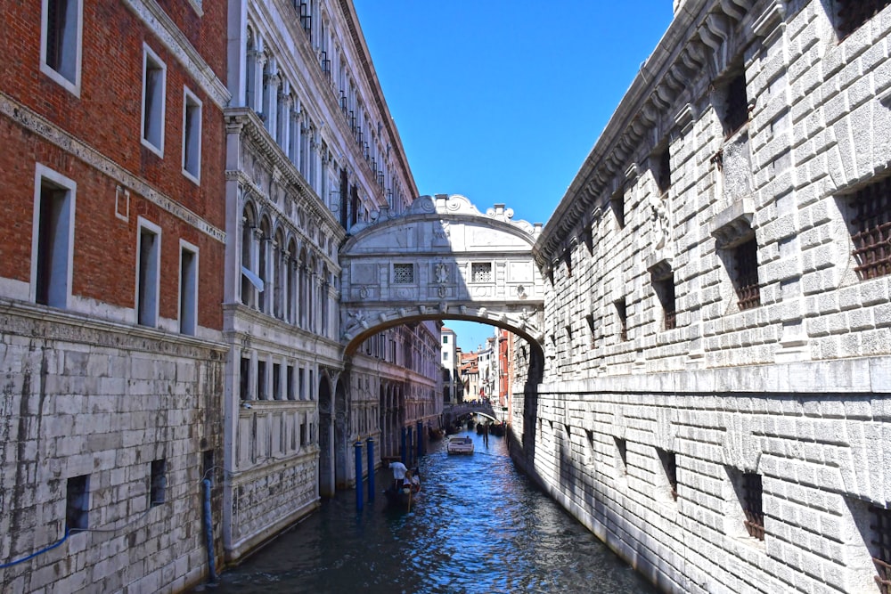 a canal between two brick buildings with Bridge of Sighs in the background