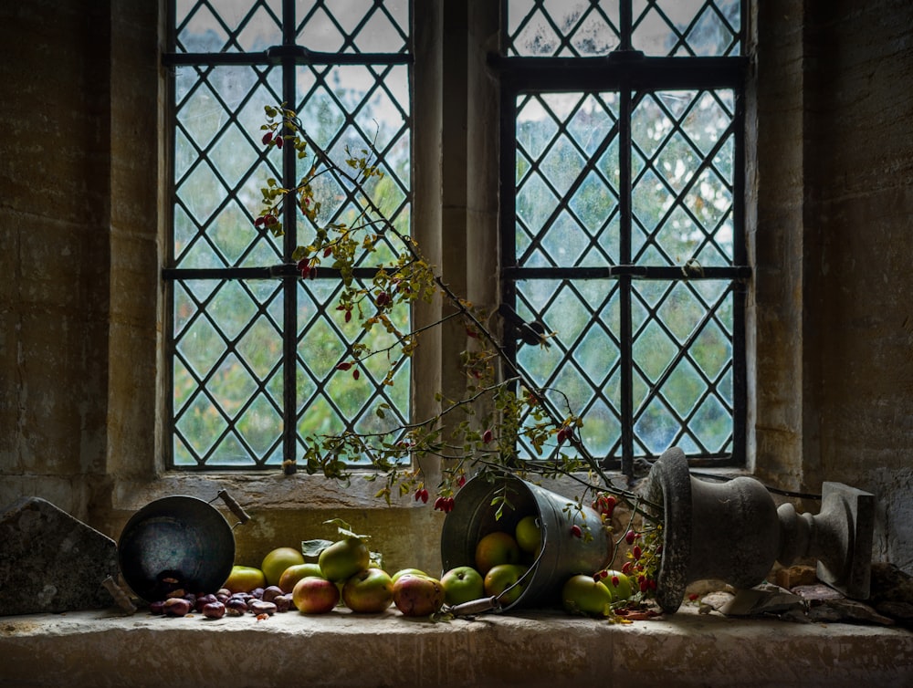 a basket of fruit sits on the ground in front of a window