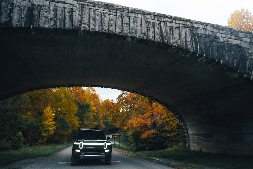 a car driving under a bridge