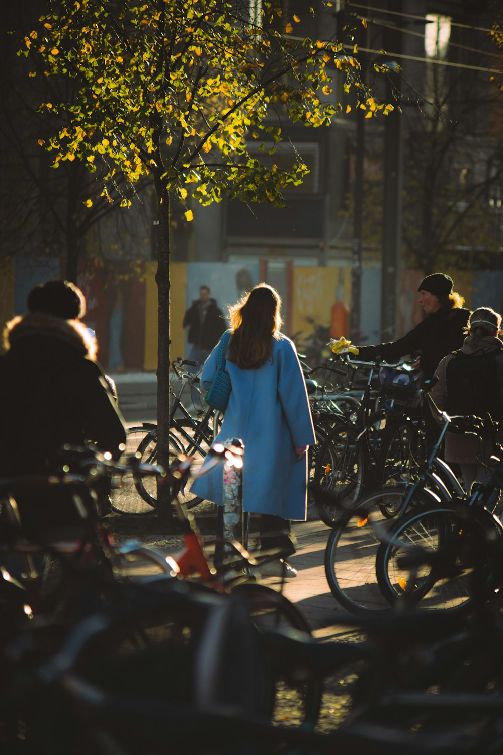 a person in a blue dress walks down a sidewalk