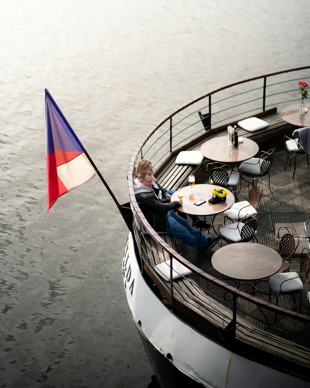 Una persona sentada en un barco con una bandera