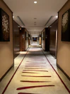 Peaceful hallway lined with traditional art leading to the standard rooms.