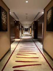 Peaceful hallway lined with traditional art leading to the standard rooms.