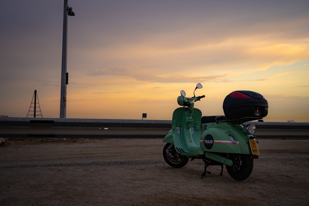 a green motorcycle parked on a beach