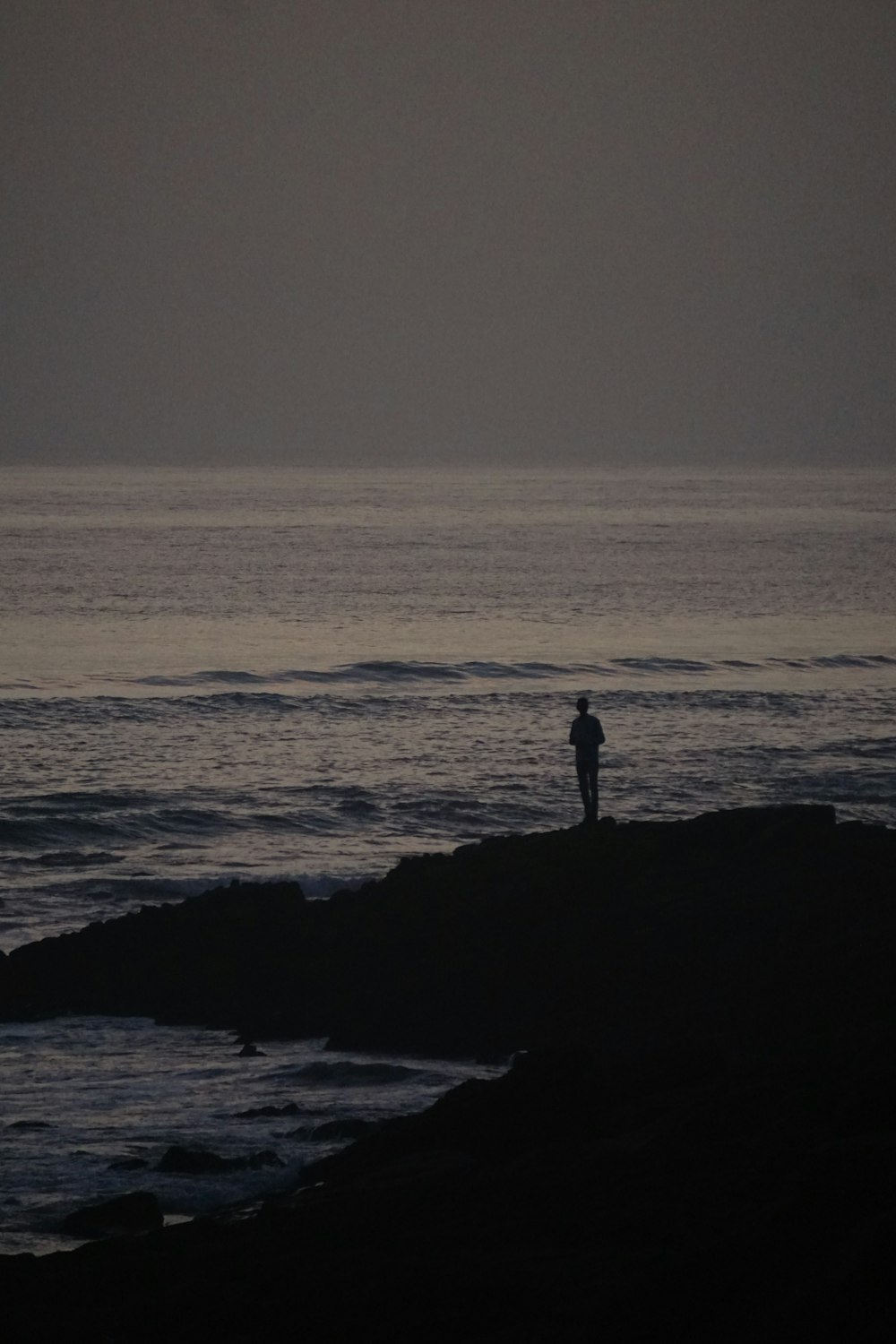 a person standing on a rocky beach