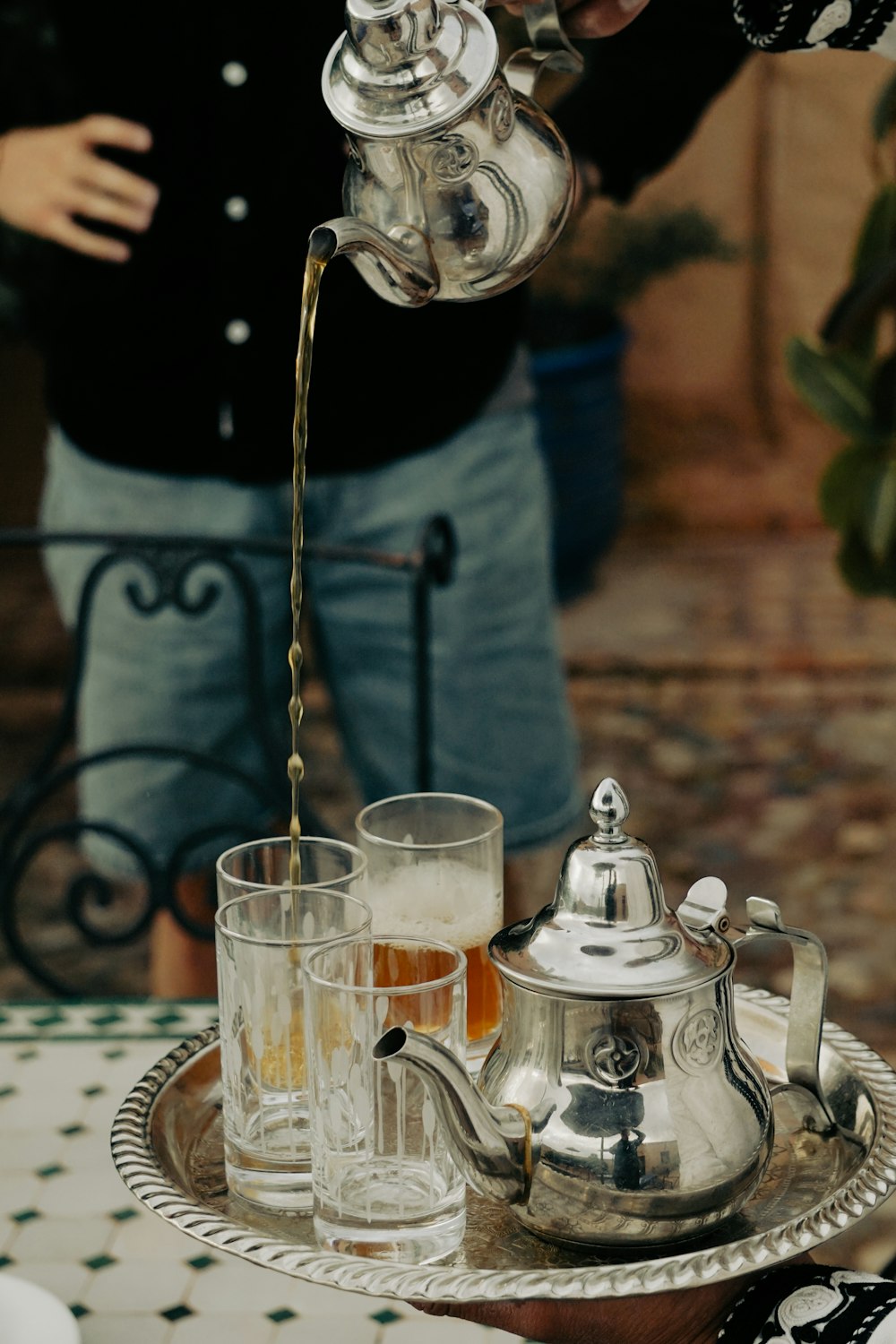 a person pouring a drink into a glass