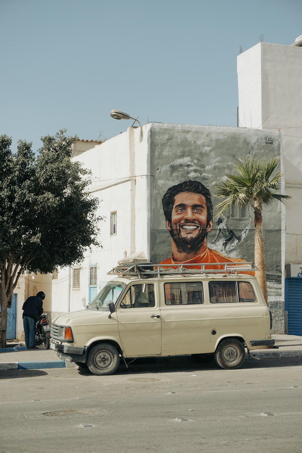 a van parked in front of a building with a painting on it