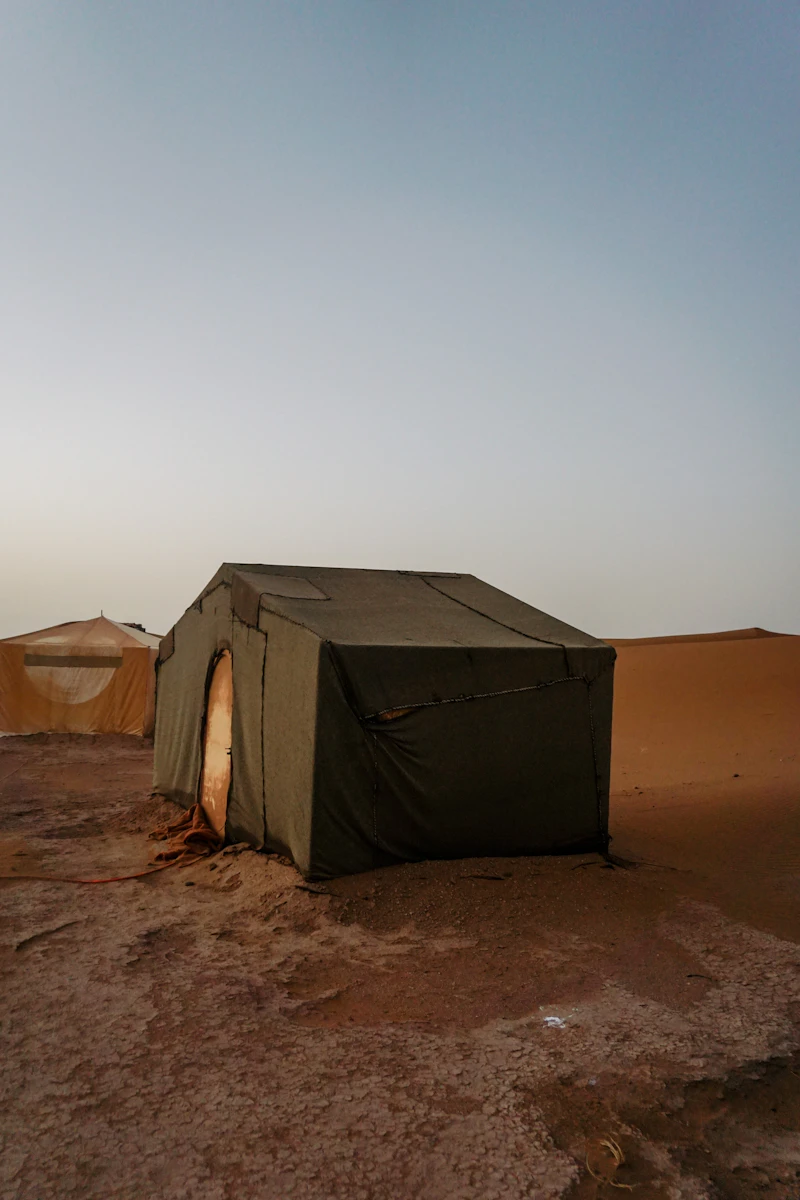 Multiple lit tents desert camp starry night Sahara