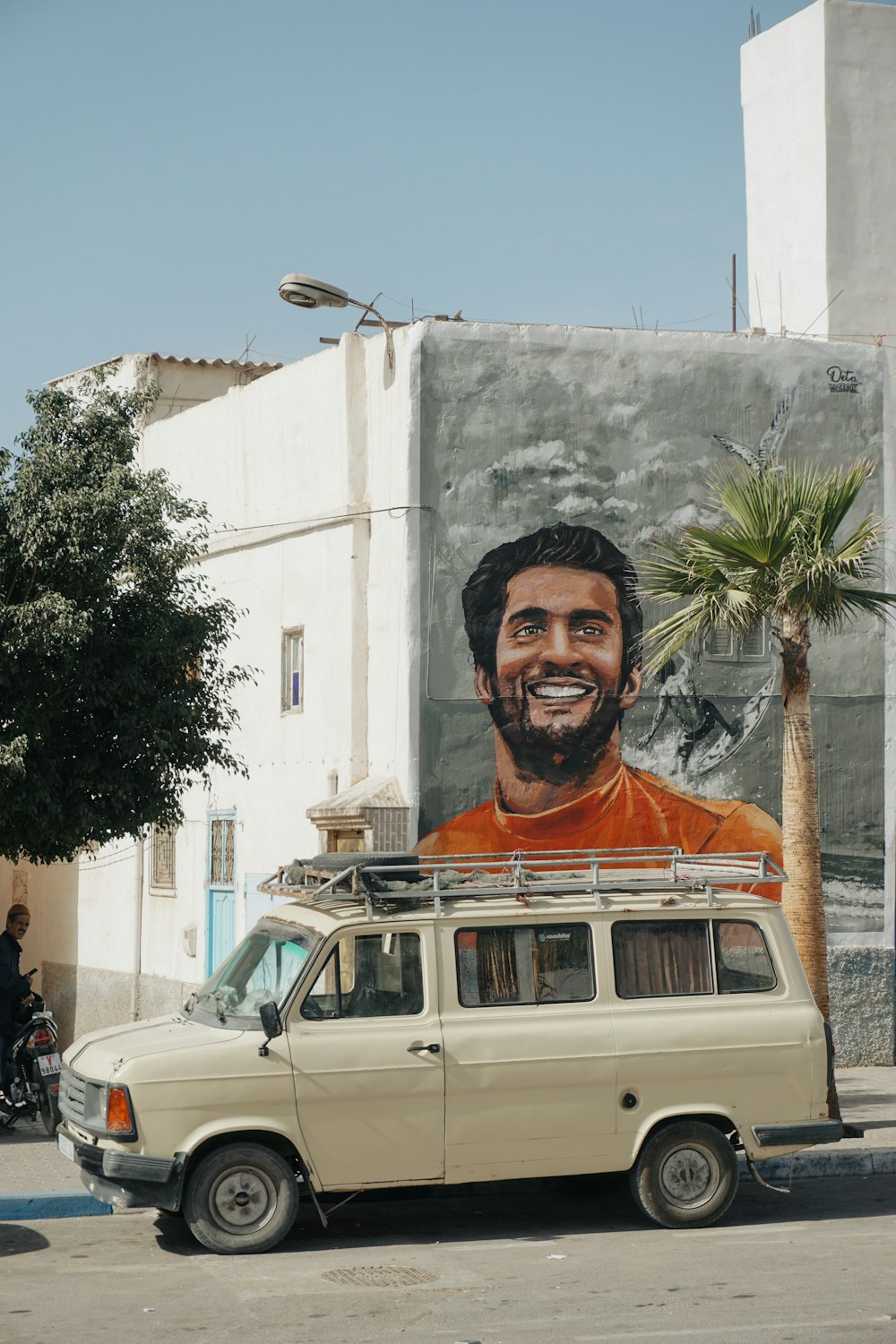 Una camioneta estacionada frente a una pintura de un hombre en una pared
