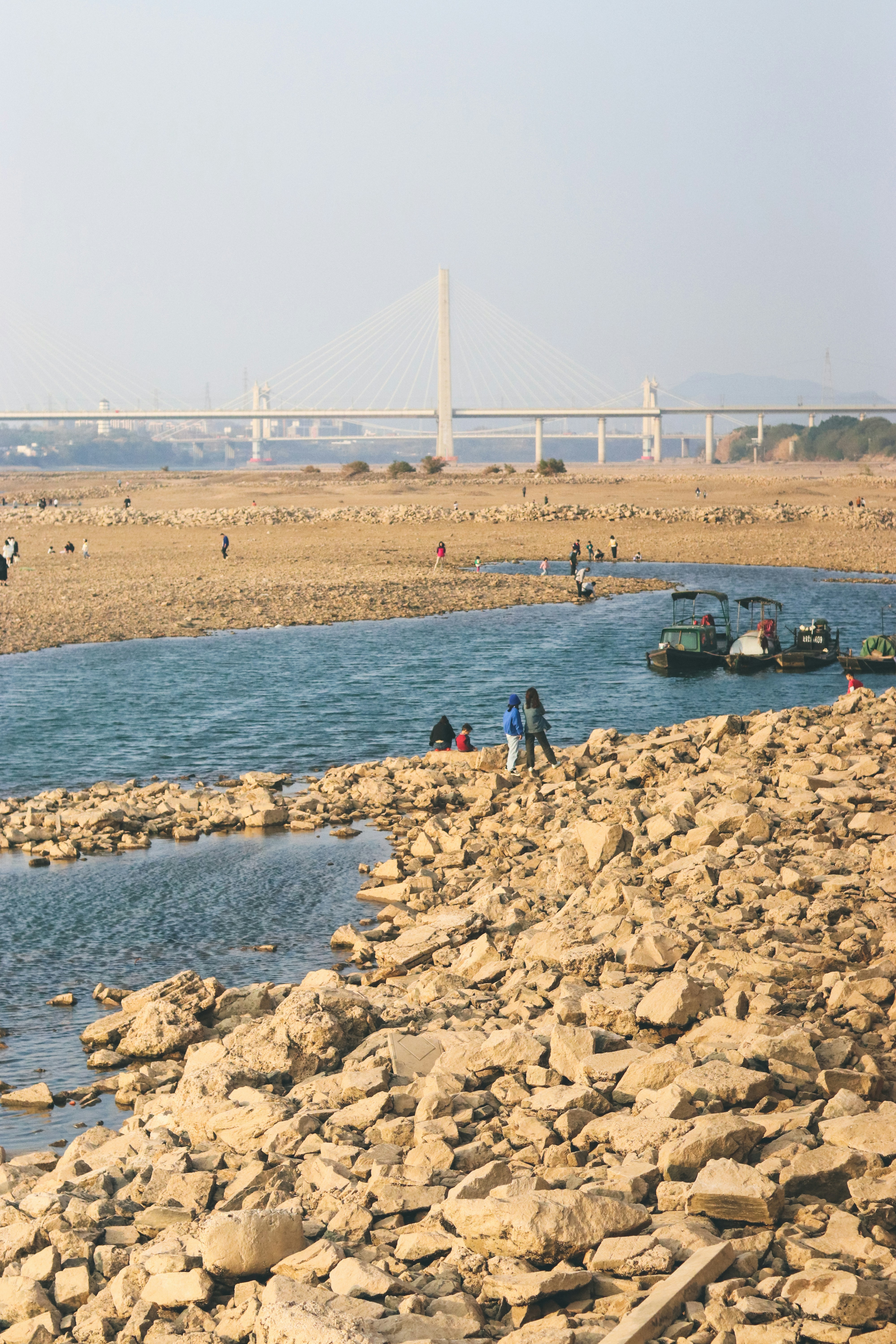 a rocky beach with a bridge in the background