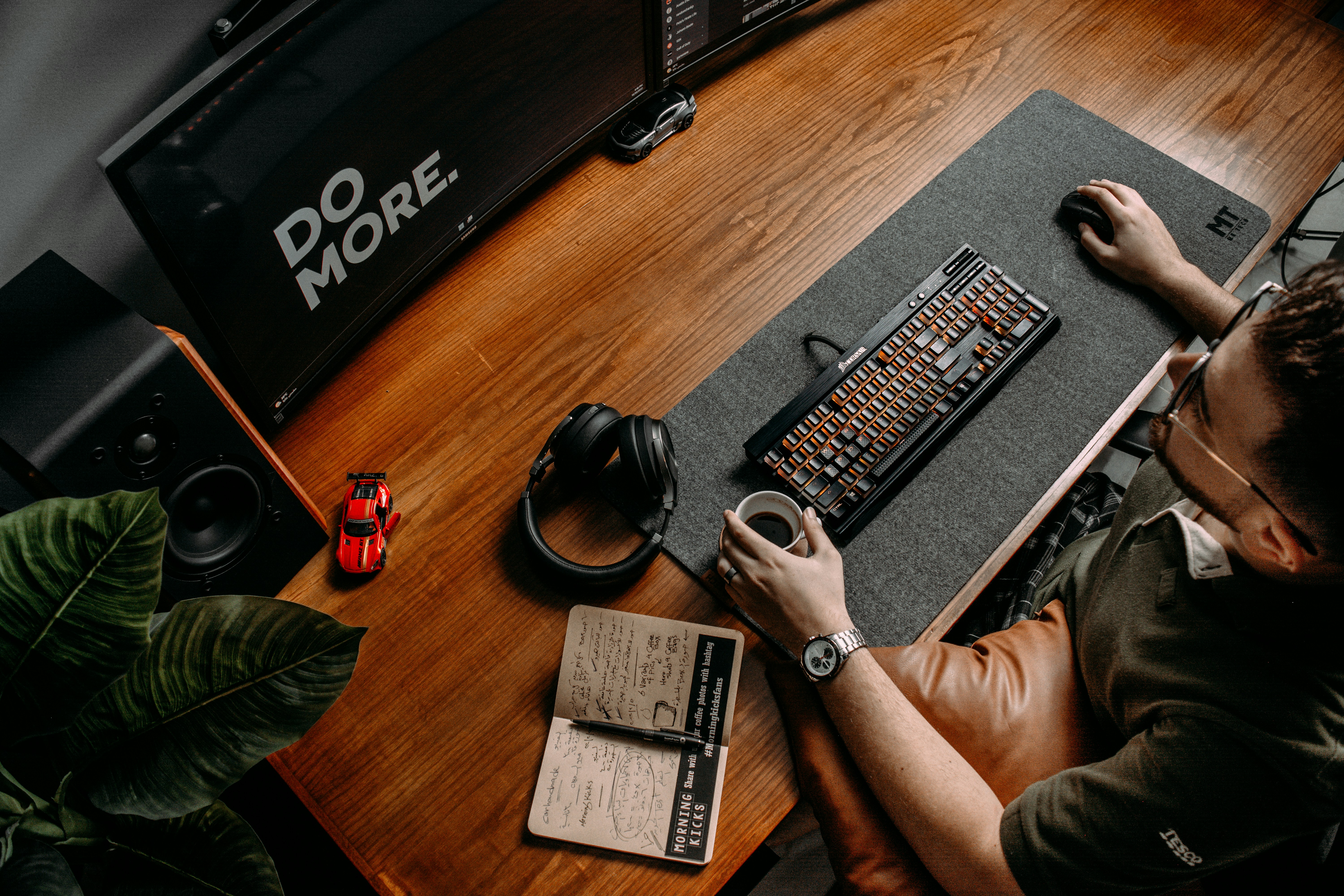 a person sitting at a desk with a computer and headphones