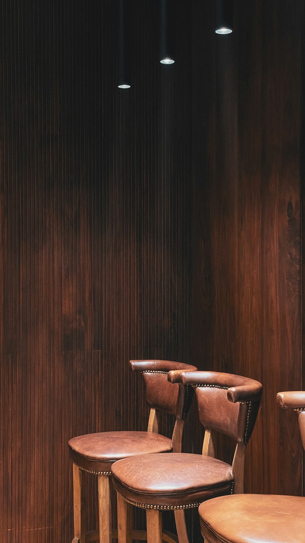 a group of chairs in front of a wood wall