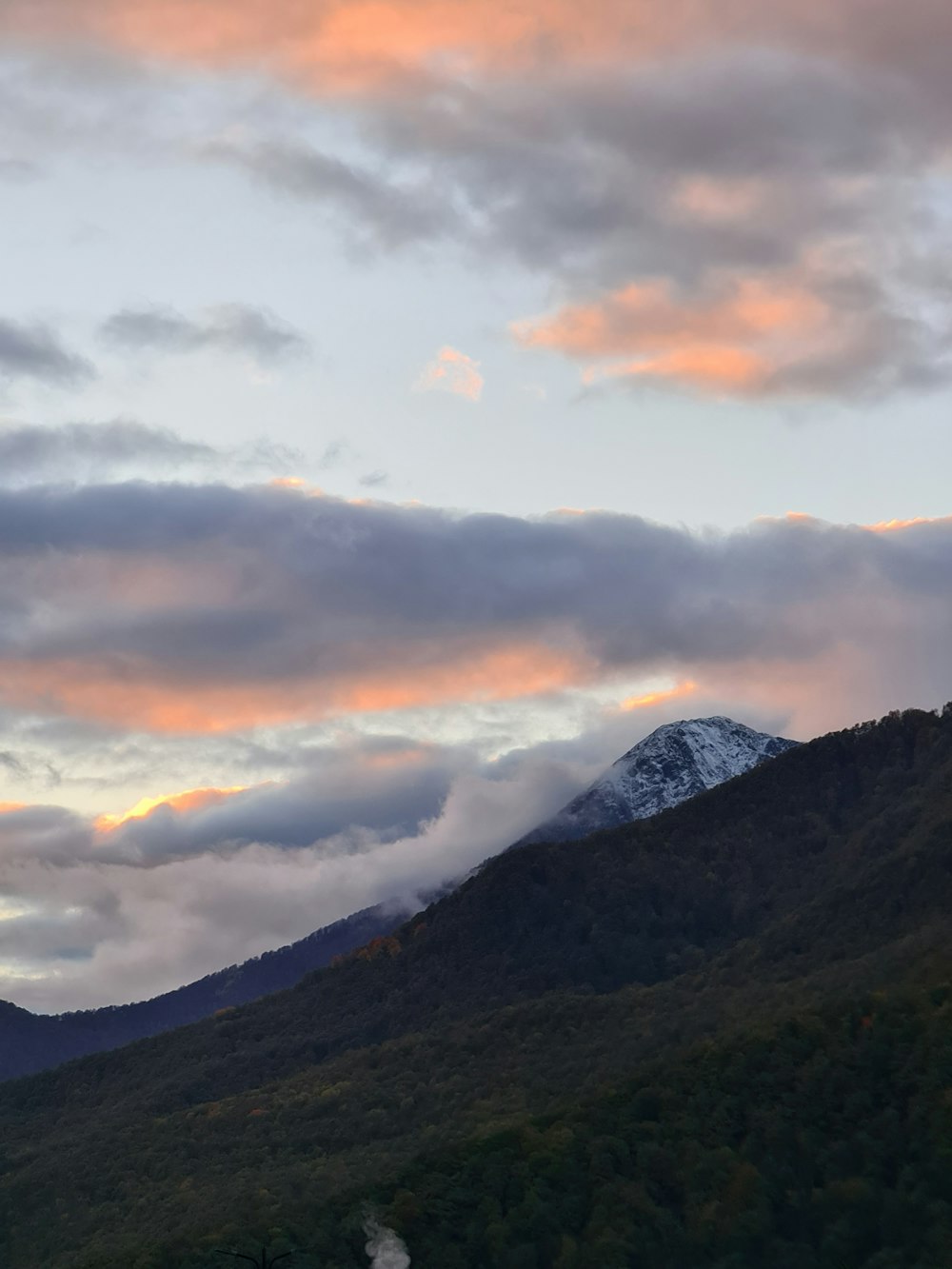 a mountain with clouds above it