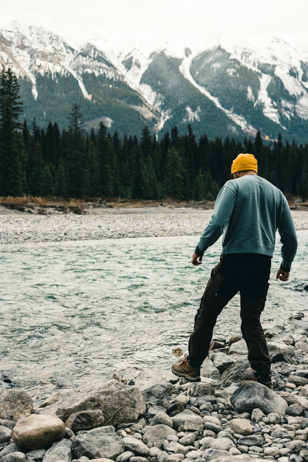 a man walking on a rocky path with a mountain in the background