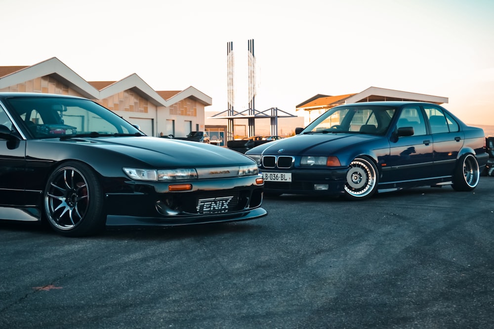 a couple of cars parked in a parking lot with a building in the background