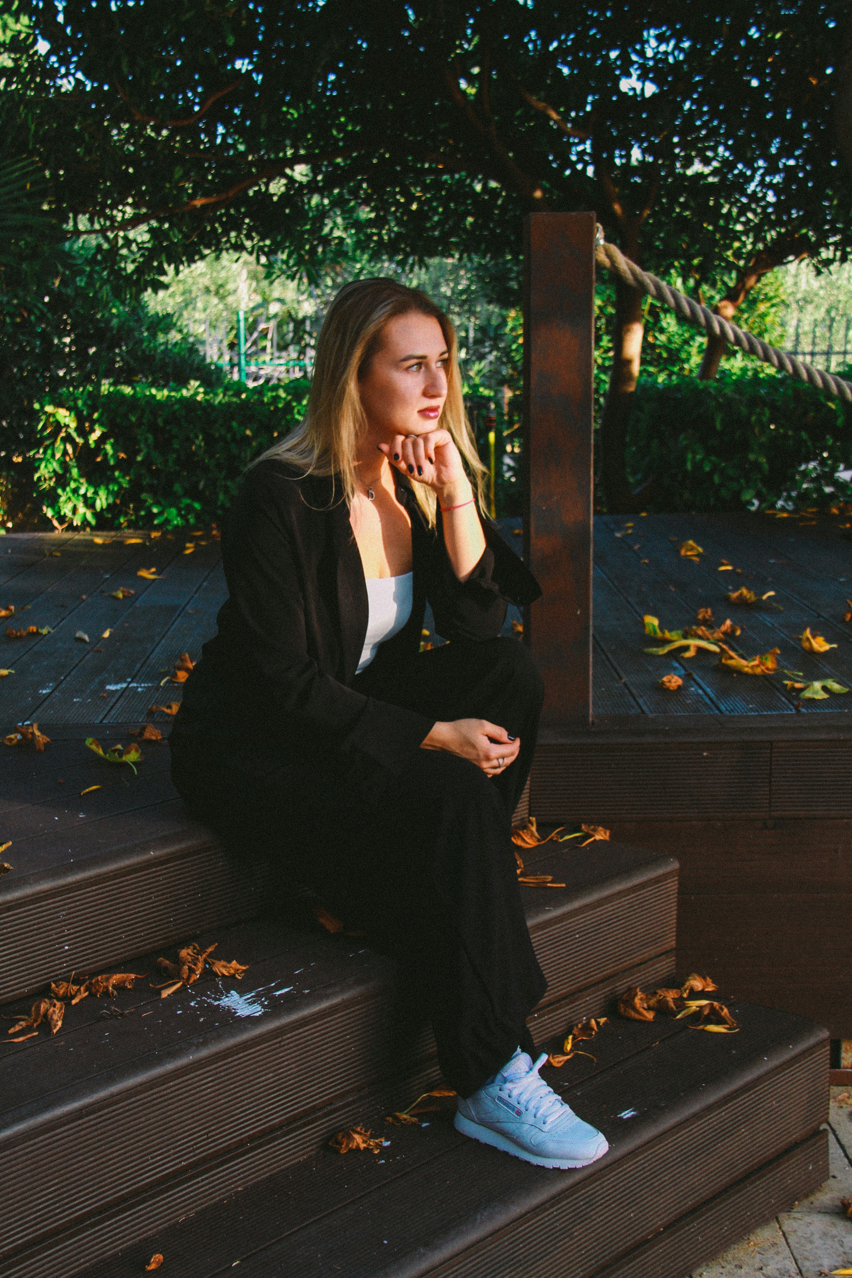 Woman sitting on a bench outdoors in a calm editorial portrait