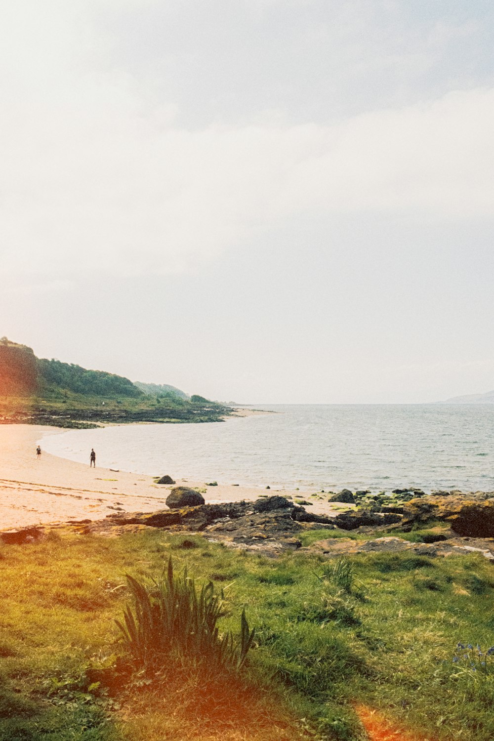 a beach with people walking on it