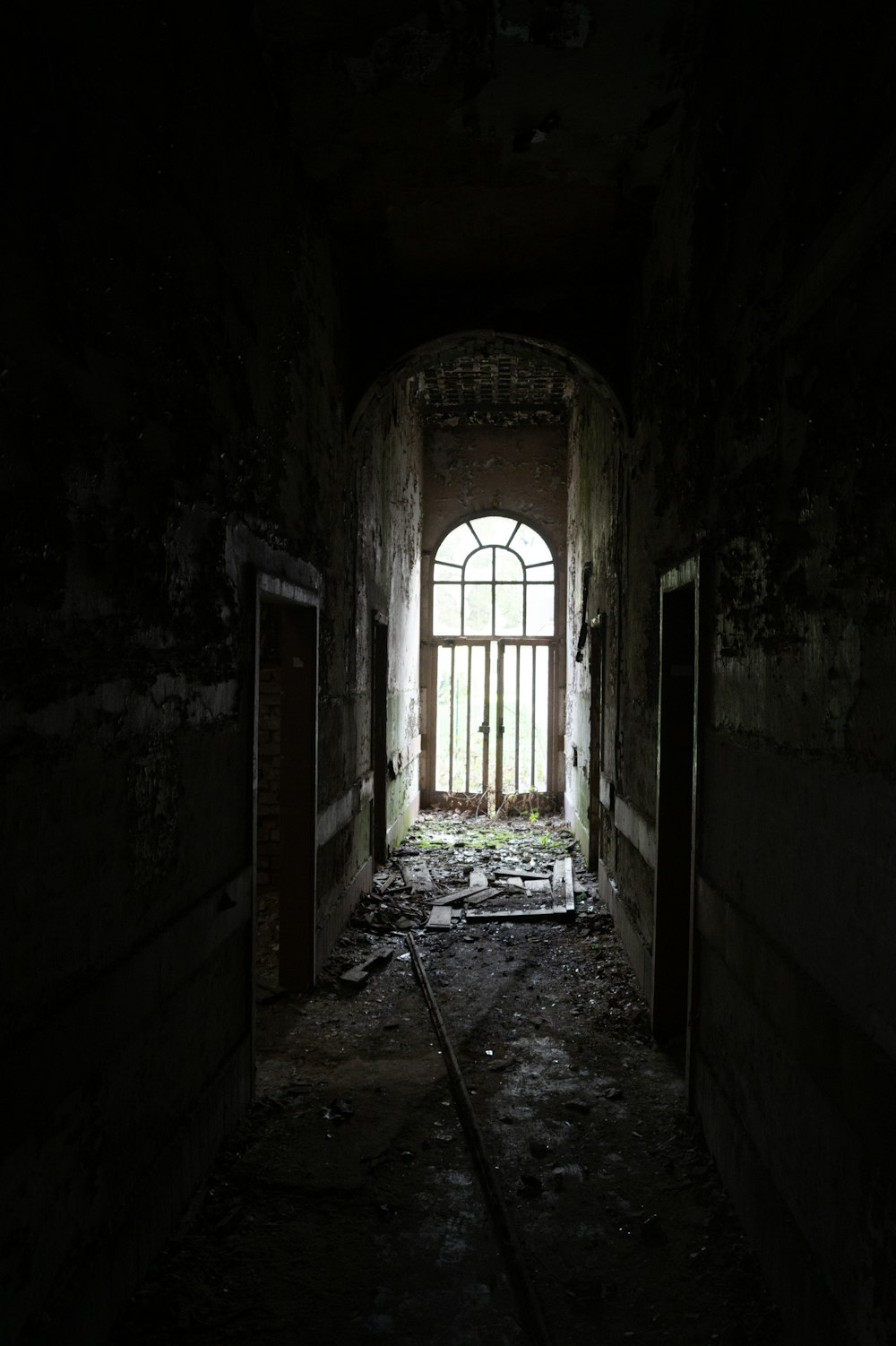 a dark room with a door and windows