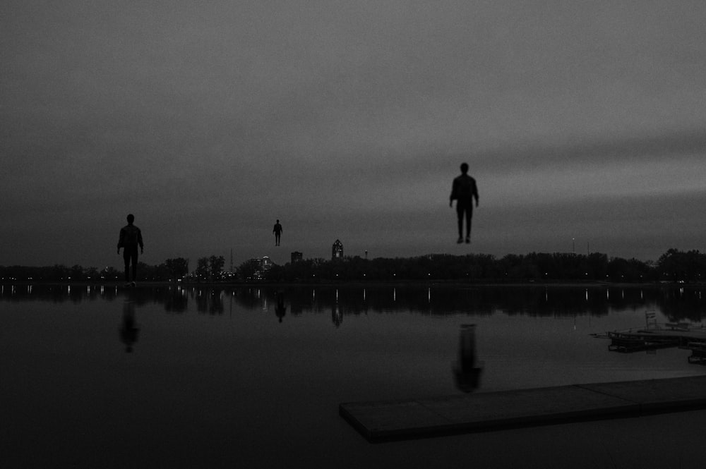 a group of people standing on a dock by a body of water