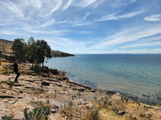 A person standing on a rocky shore — Lake Titicaca, Peru