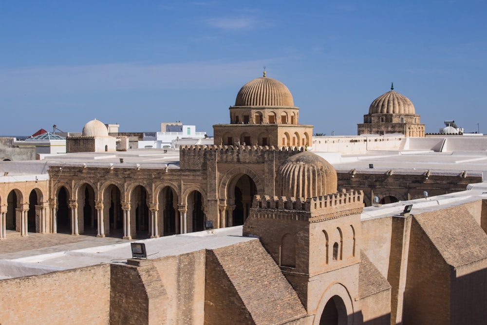 a large building with domed roofs with Kairouan in the background