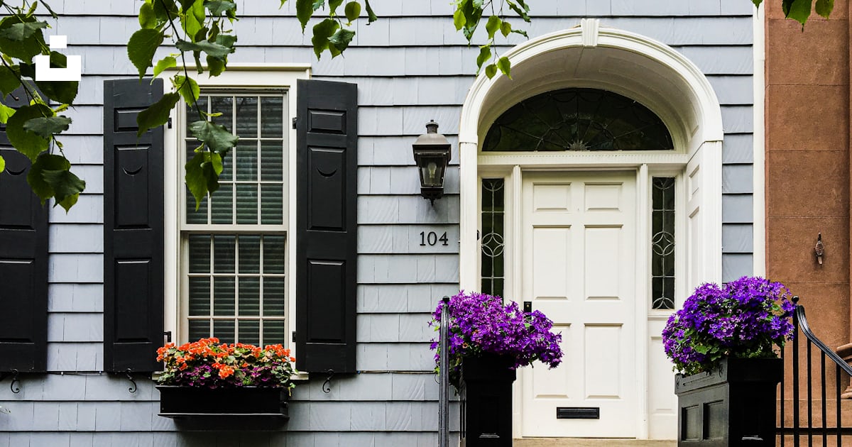 A building with a few windows and flowers in the front photo – Free New ...