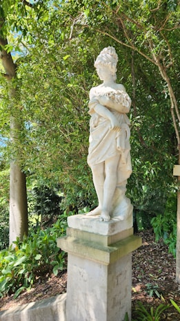 Elegant marble statue displayed in a sunlit garden setting
