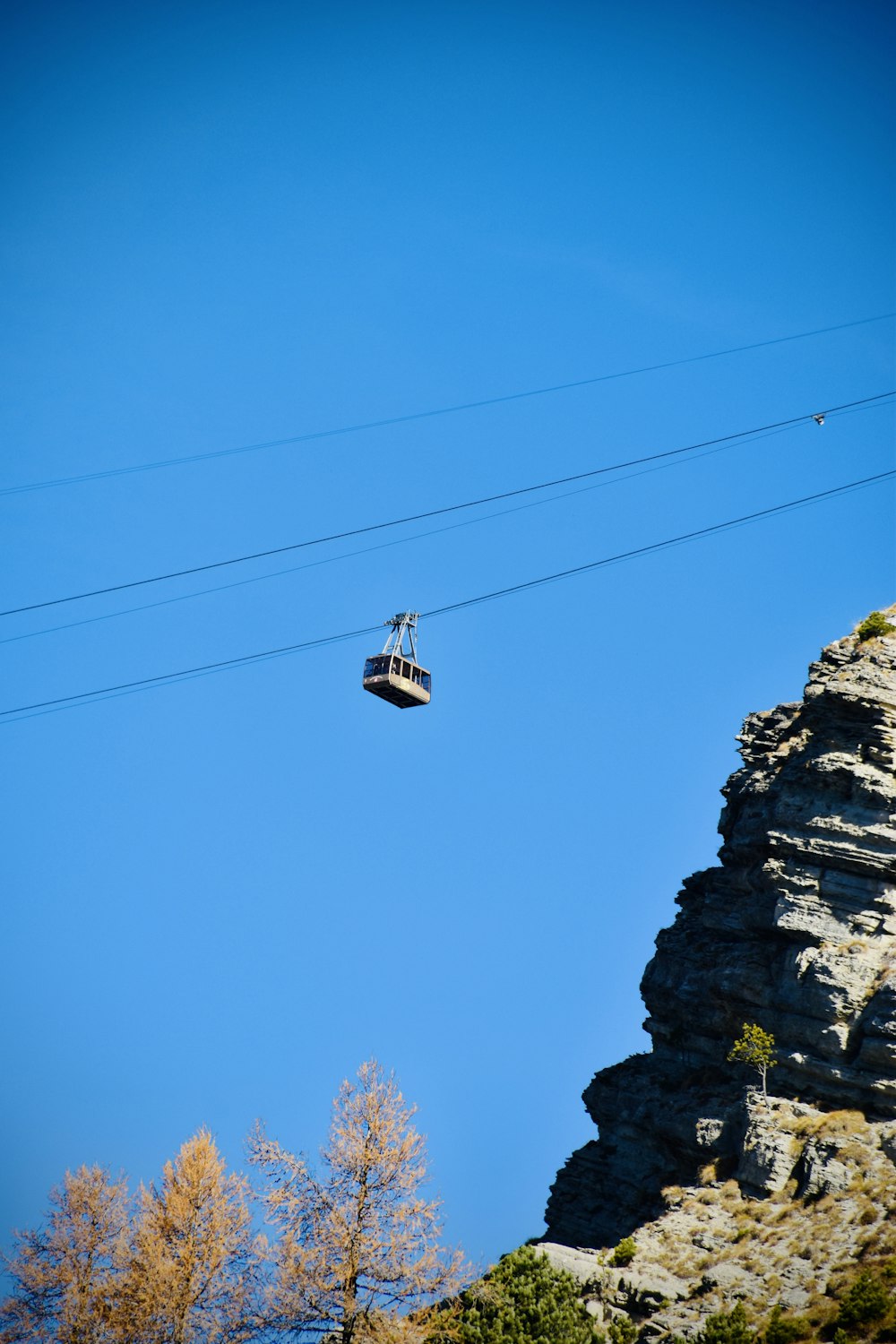 a cable car above a rocky cliff