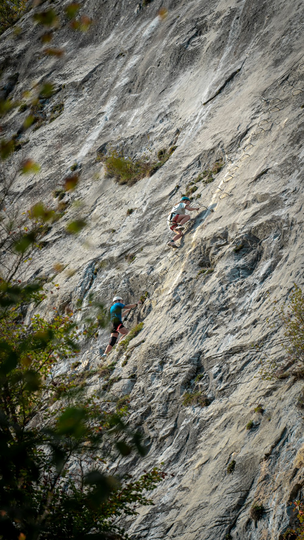 a couple of people climbing a rock