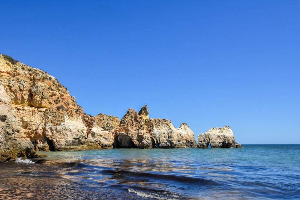 a rocky cliff next to the water